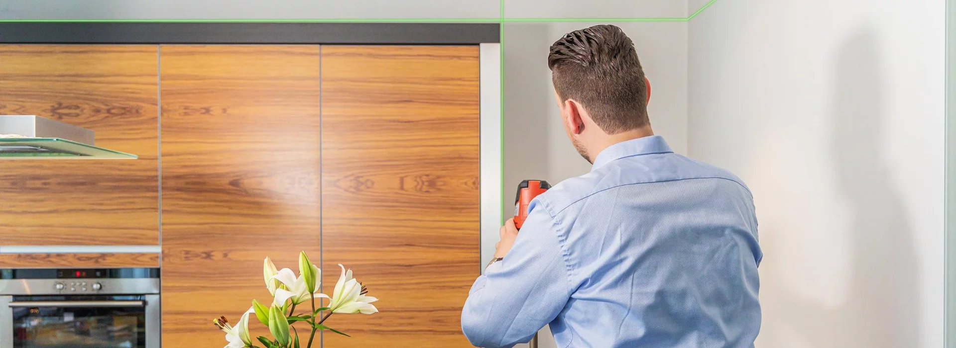 Gero Keuthen steht in einer Küche und arbeitet mit einem Laser